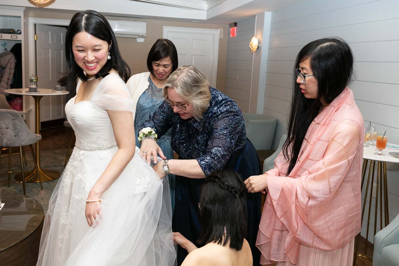 Megan with her bridesmaids adjusting her dress